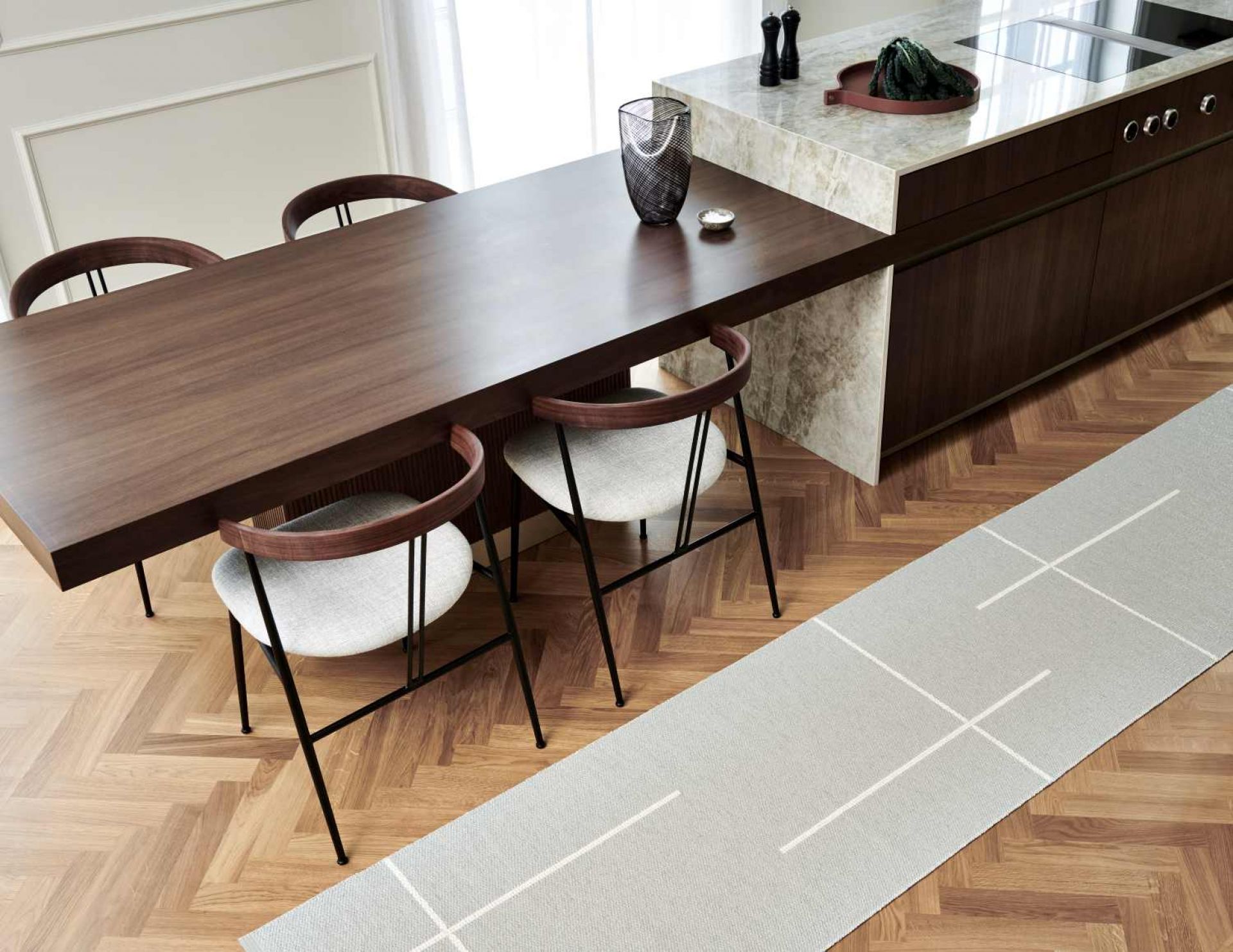 Fred Teppich Pappelina, 70x270 cm, in Grau mit weißem Muster auf Holzboden unter Esstisch.