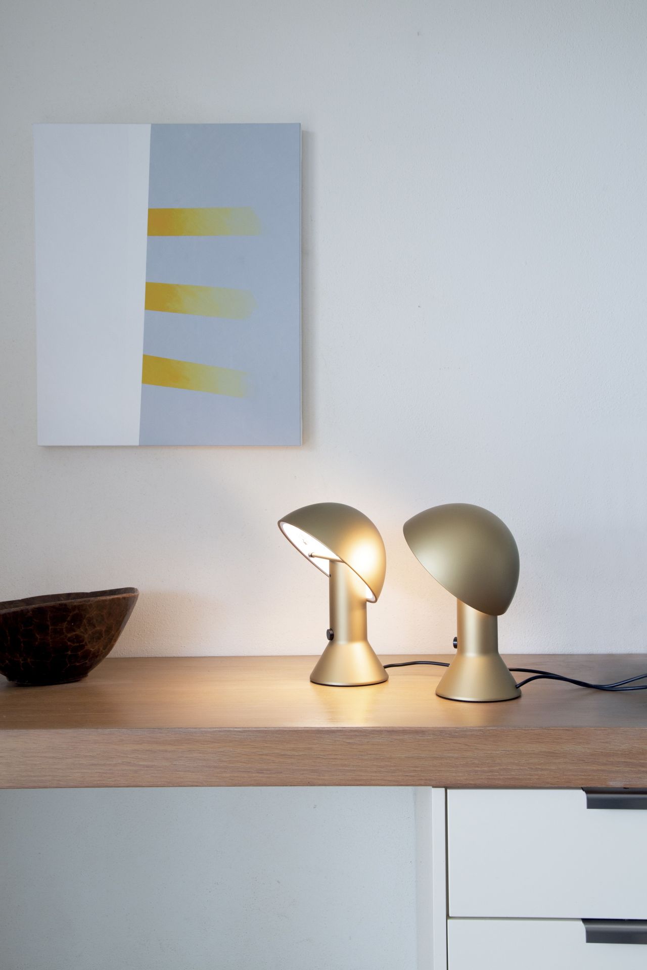 Goldene Elmetto Tischleuchten von Martinelli Luce auf einem Holztisch, moderne Innenarchitektur mit Kunst.