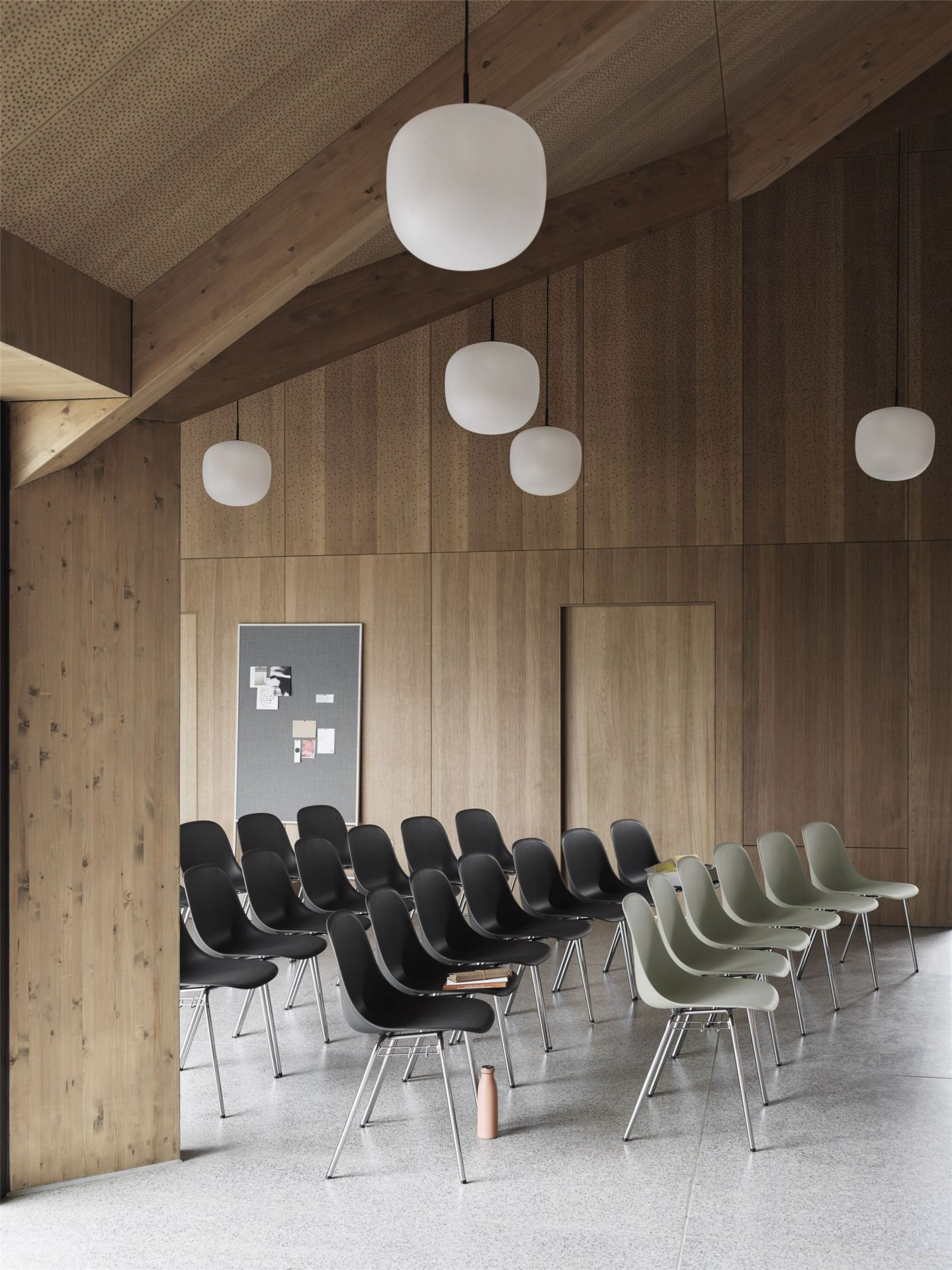 Reihe von Muuto Fiber Stühlen mit A-Base Gestell in Schwarz und Grau im Konferenzraum.