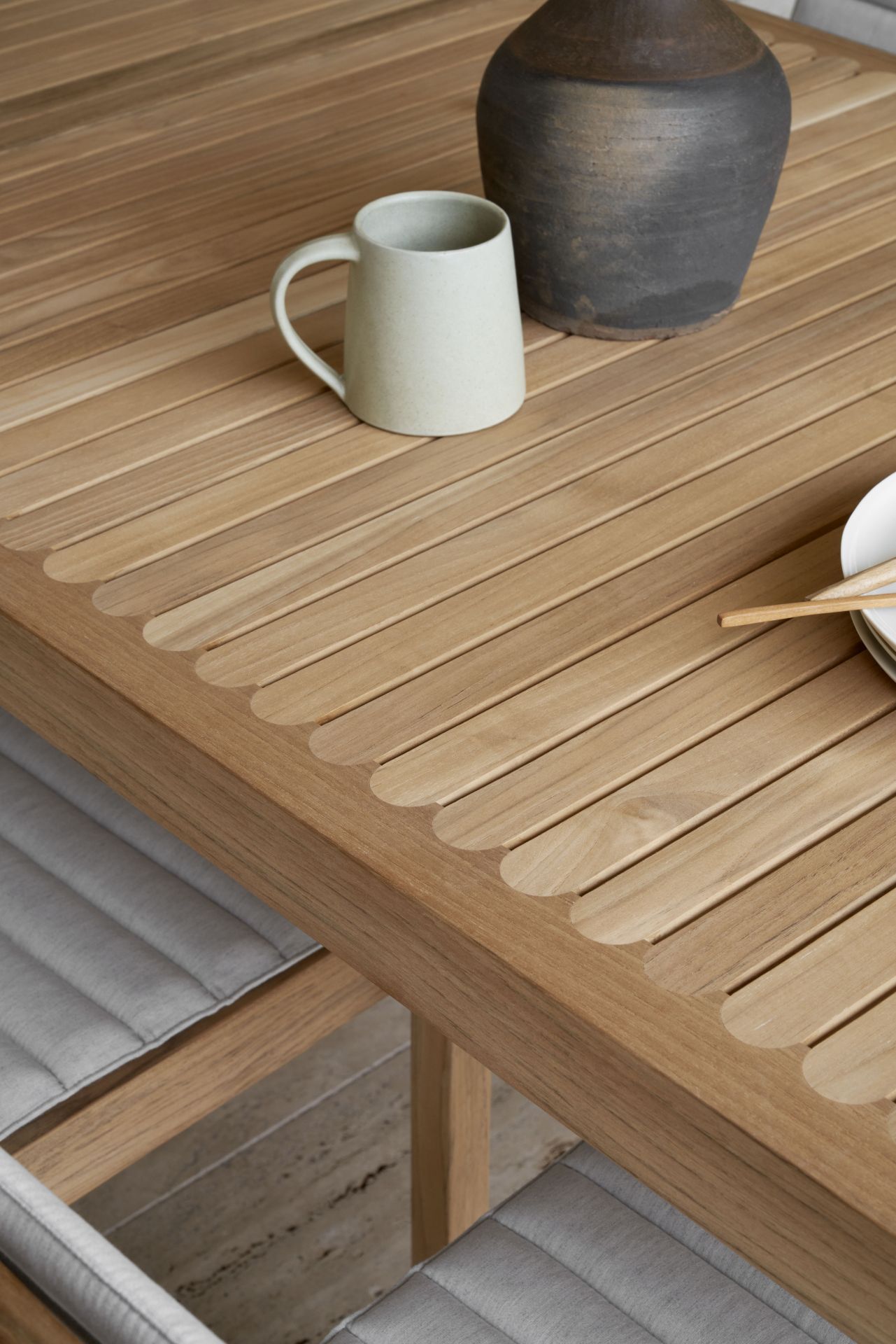 Detailaufnahme des AH902 Esstisch Outdoor von Carl Hansen & Søn aus Teakholz mit Geschirr.