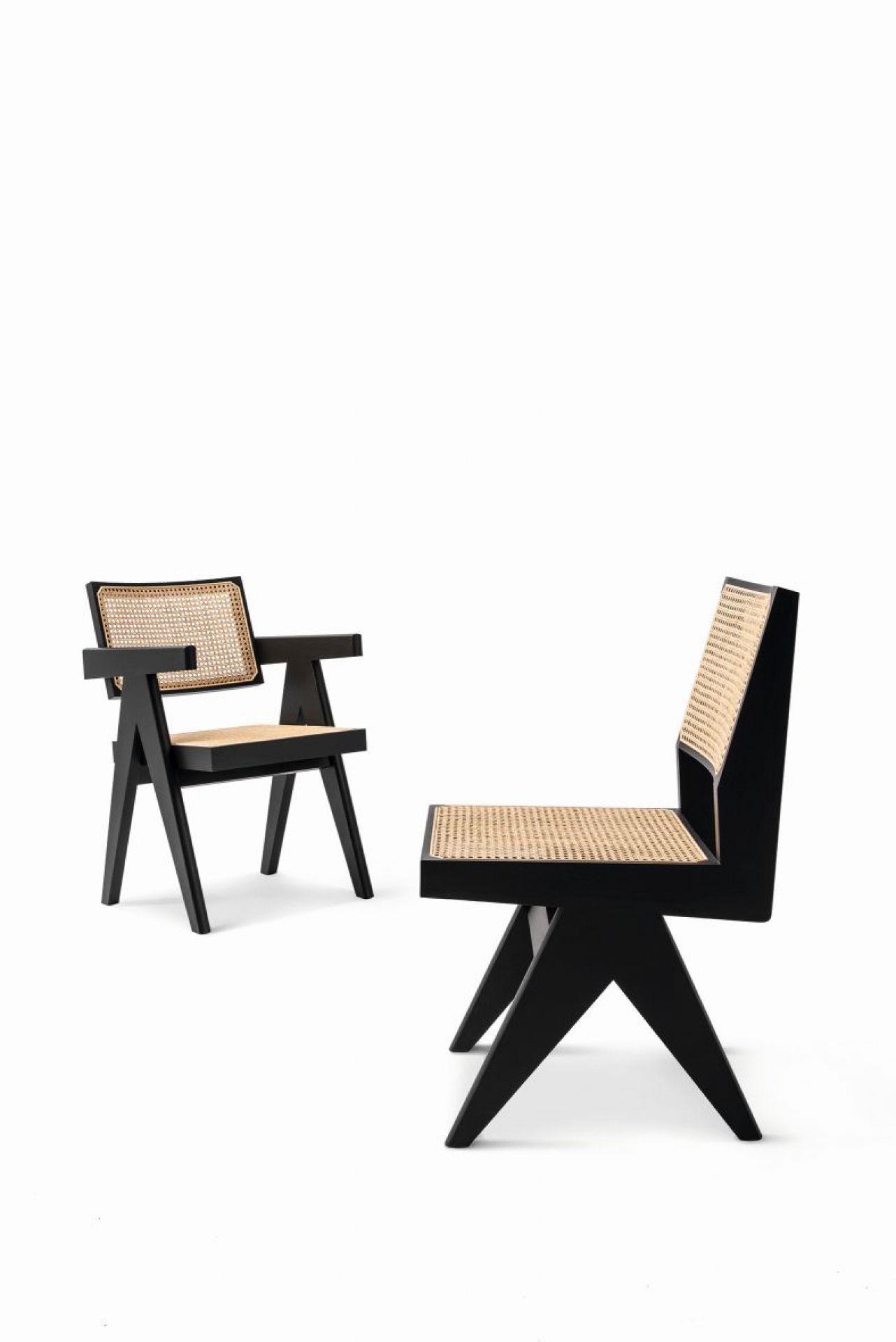Zwei schwarze Capitol Complex Stühle mit Wiener Geflecht von Cassina auf weißem Hintergrund.
