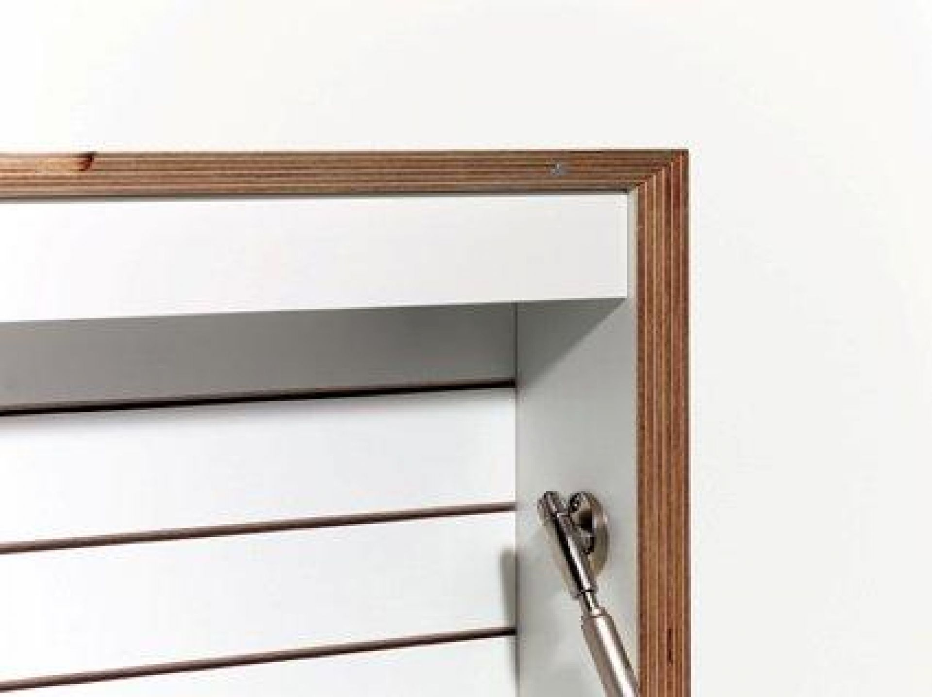Detailaufnahme des weißen Flatbox Sekretärs von Müller Möbelwerkstätten mit Holzrahmen und Klappenmechanismus.