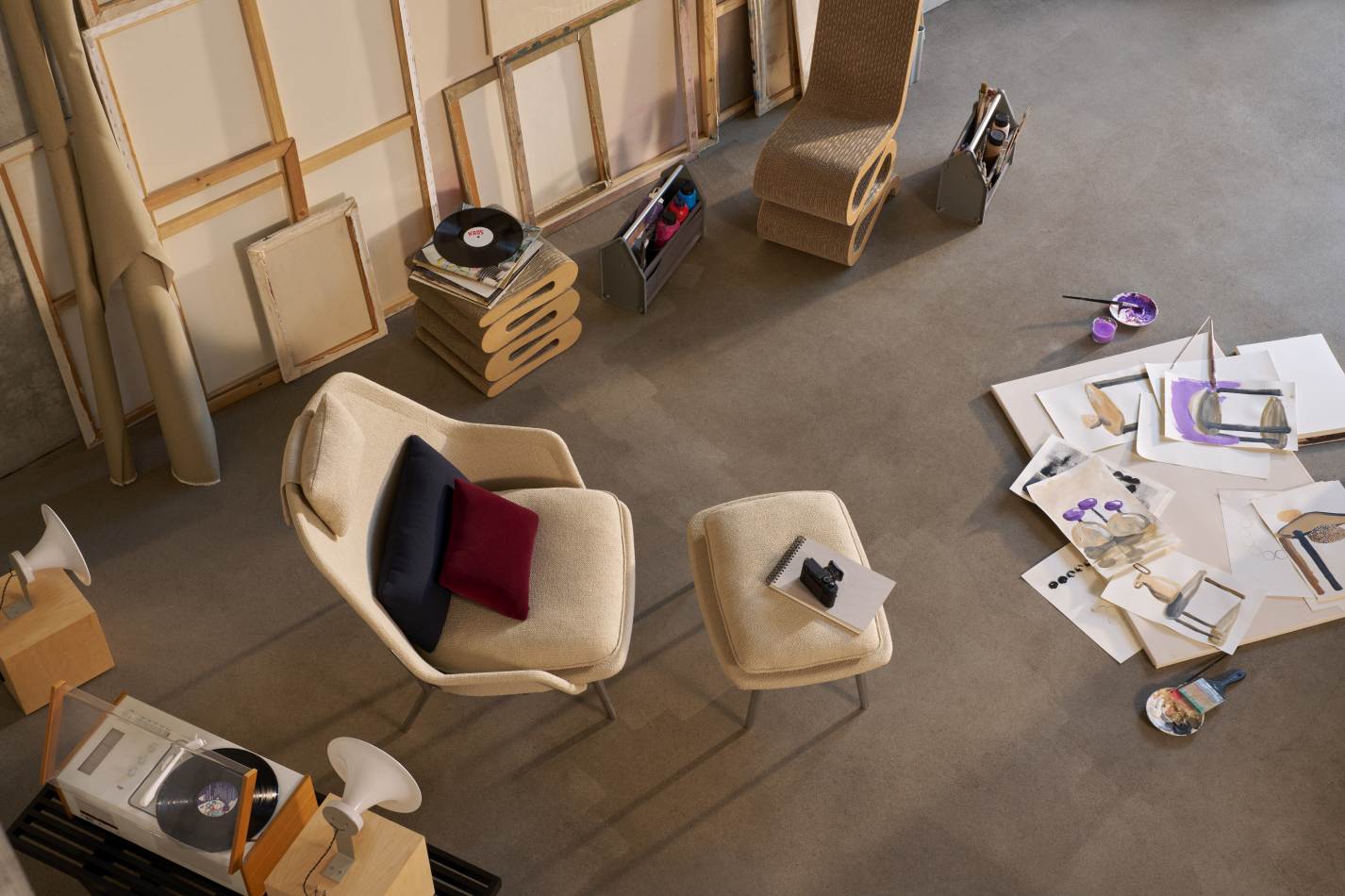 Vitra Slow Chair Sessel mit Stoffbezug in Beige, kombiniert mit passendem Hocker und Kissen.