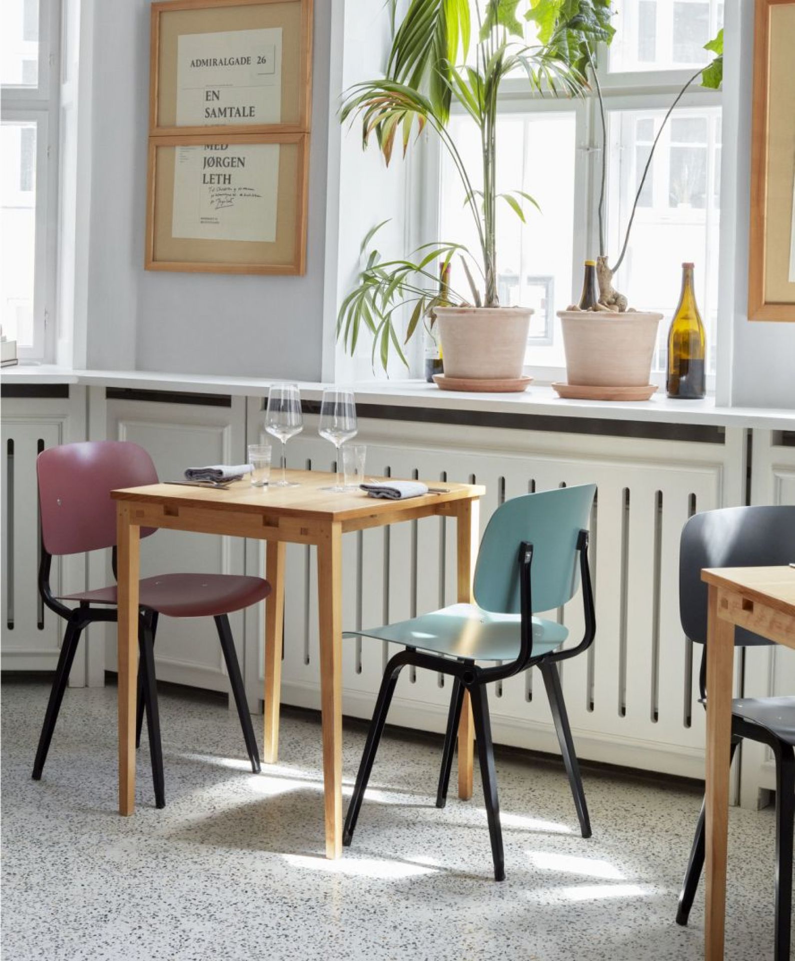 Esszimmer-Szene mit Holztisch und farbigen Hay Revolt Chairs, modernes skandinavisches Design für Küche und Wohnbereich.