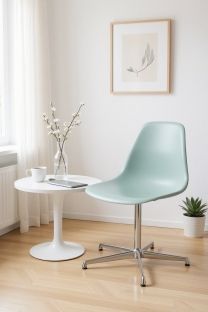 Mintgrüner Eames Fiberglass Side Chair DSL Stuhl von Vitra neben einem weißen Beistelltisch in einem hellen Raum.