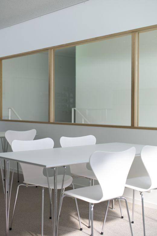 Weißer, rechteckiger Fritz Hansen Tisch mit Stühlen in einem hellen Raum. Modernes Design für Büro oder Esszimmer.