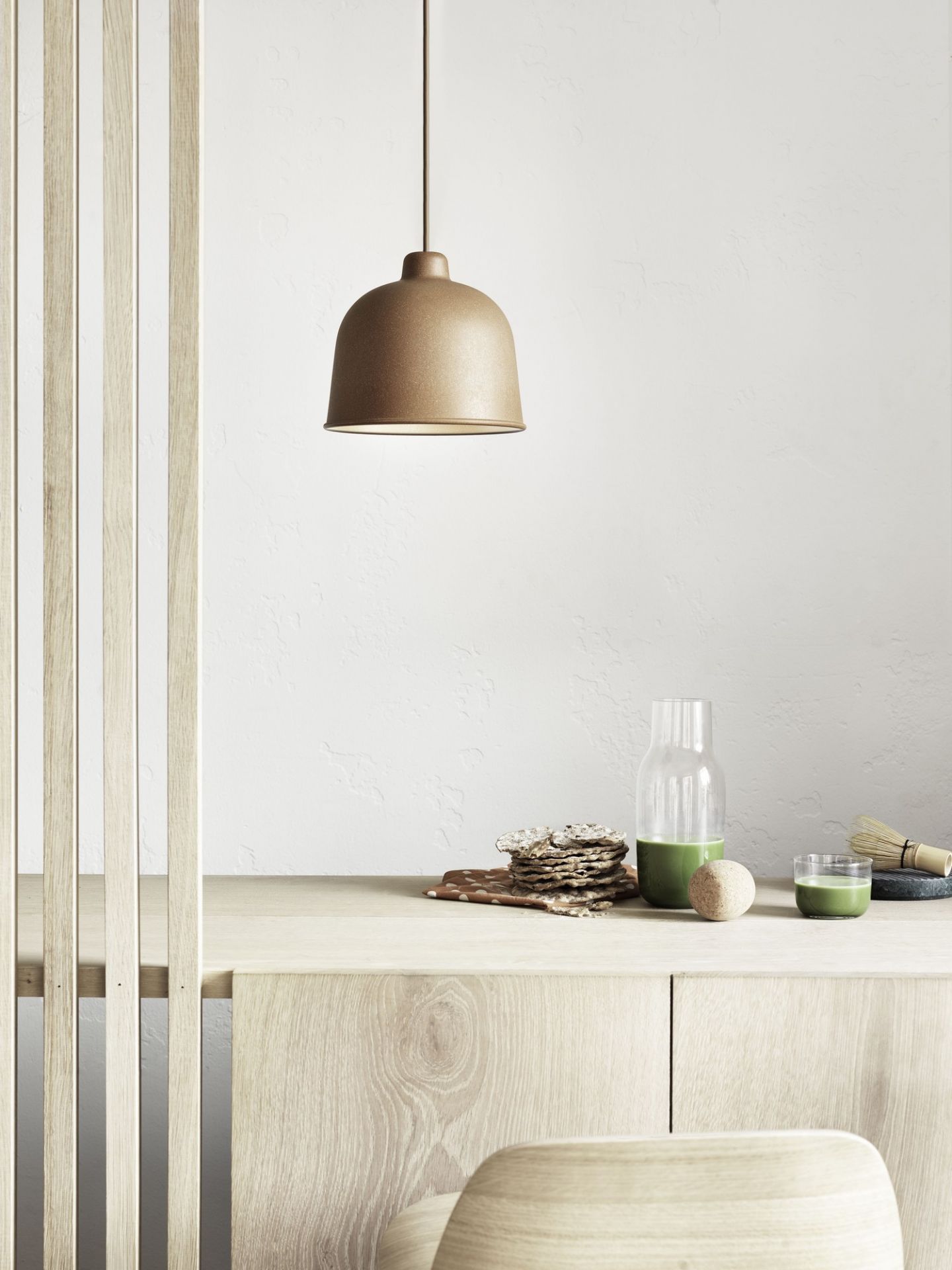 Nahaufnahme der Muuto Grain Pendelleuchte in Beige über einem Holztisch mit Matcha-Tee.