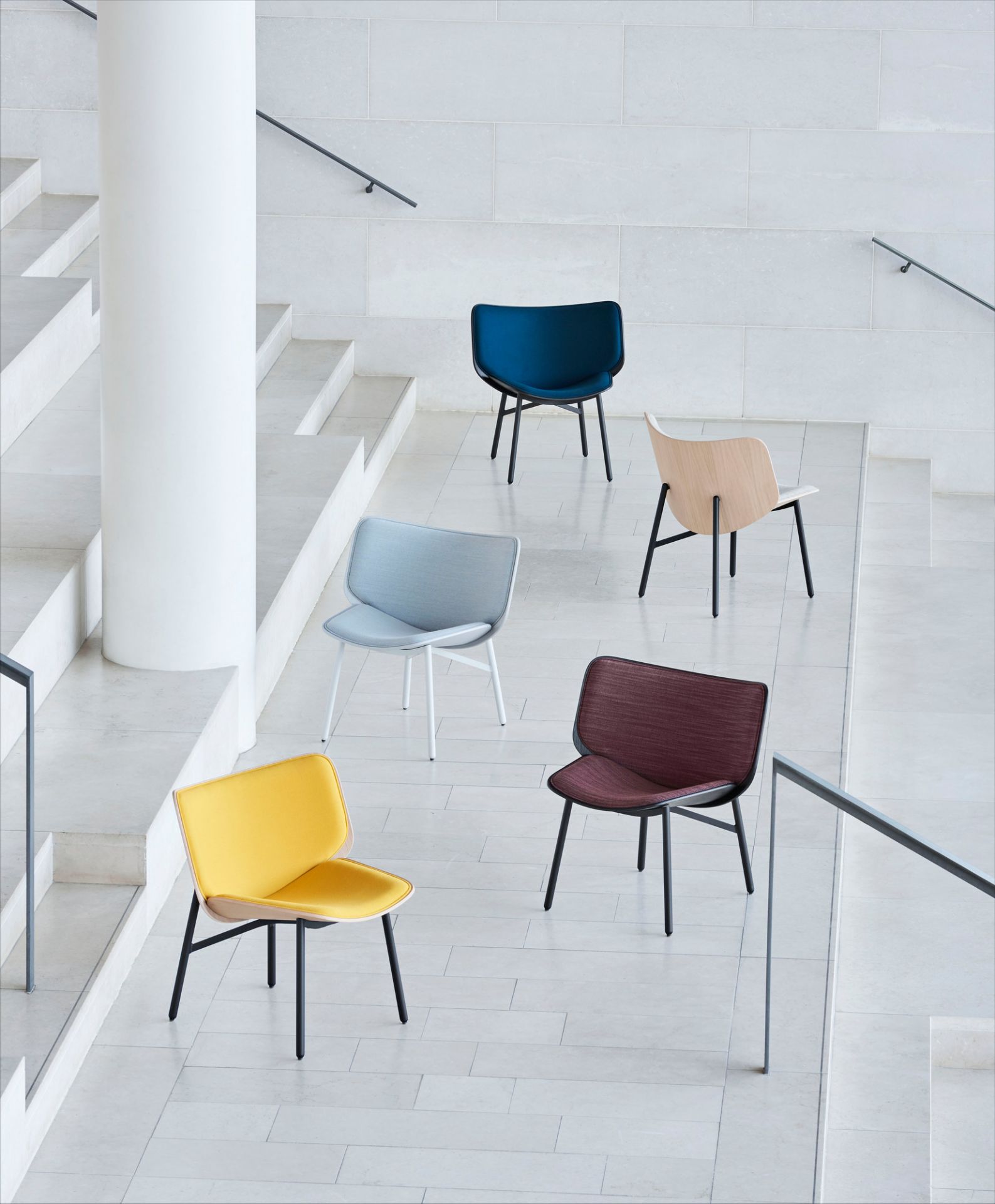 Fünf Dapper Lounge Chair Sessel von Hay in verschiedenen Farben vor einer Treppe.