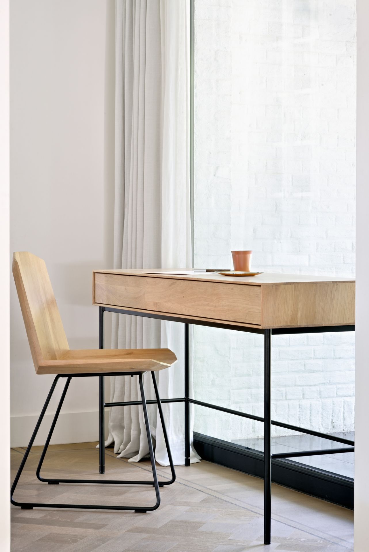 Whitebird Schreibtisch von Ethnicraft mit Holzstuhl und schwarzem Metallgestell vor hellem Hintergrund.
