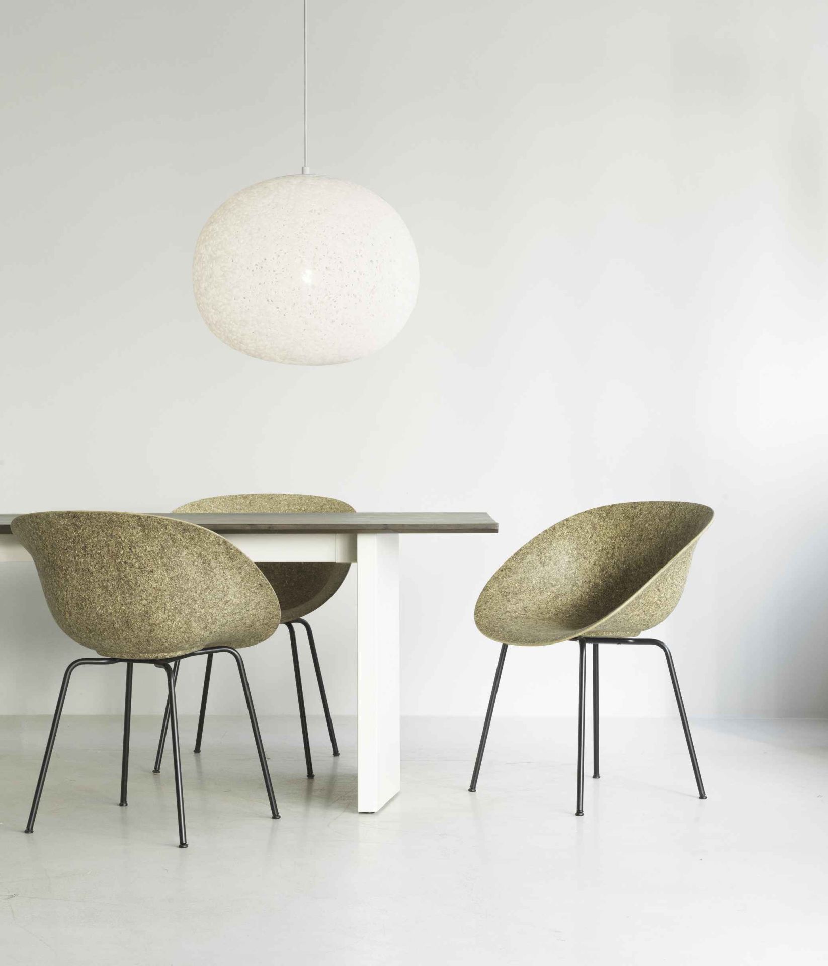 Normann Copenhagen Panel Tisch mit drei Stühlen und einer Hängelampe im minimalistischen Esszimmer.