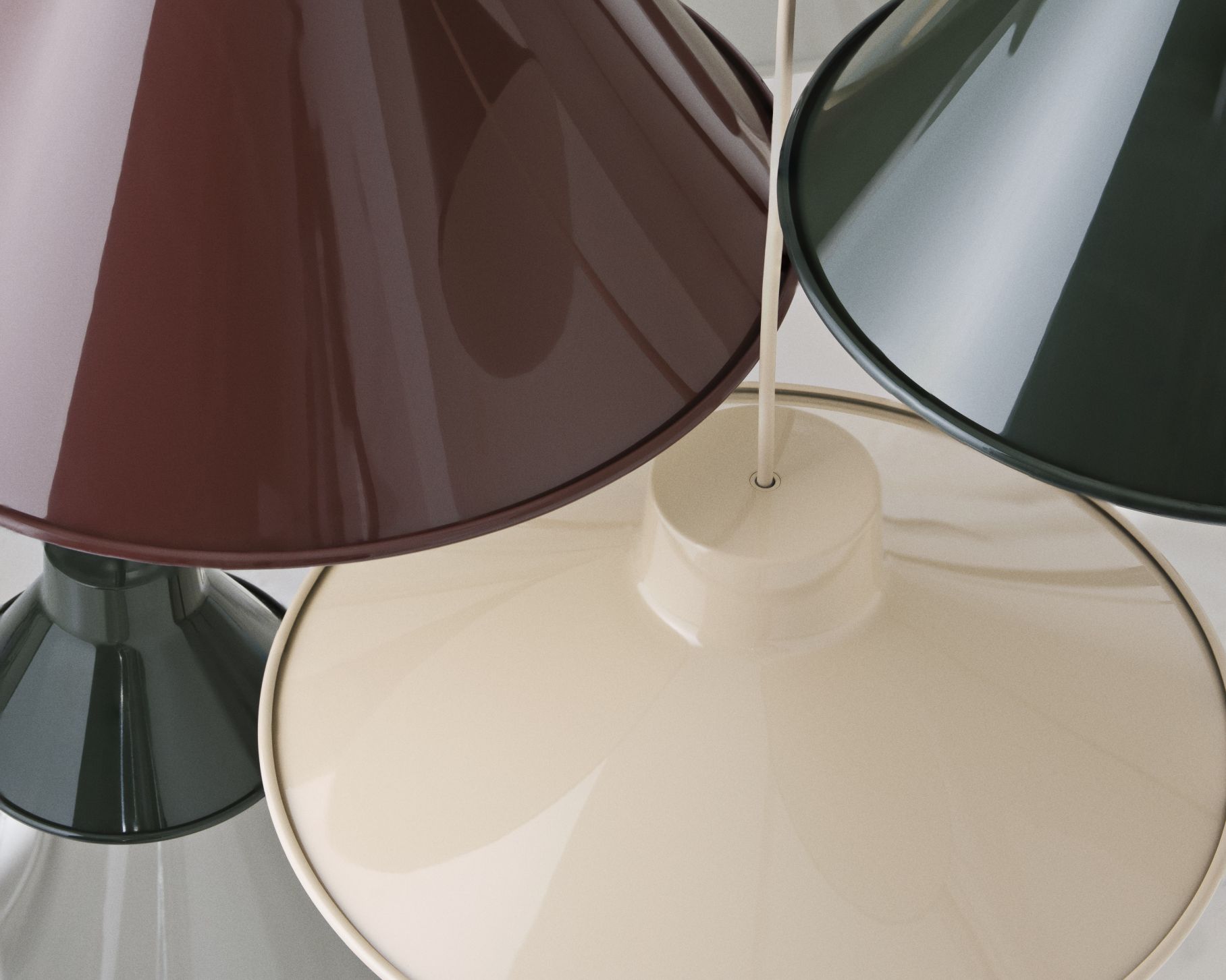 Nahaufnahme von drei Muuto Top Pendelleuchten in Grau, Braun und Beige, moderne Hängelampen für Wohnraumbeleuchtung.