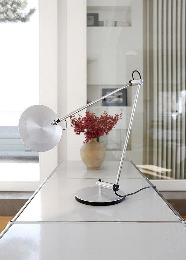 Nahaufnahme der modernen PINA LED T Tischleuchte von Baltensweiler in Silber auf einem weißen Tisch.