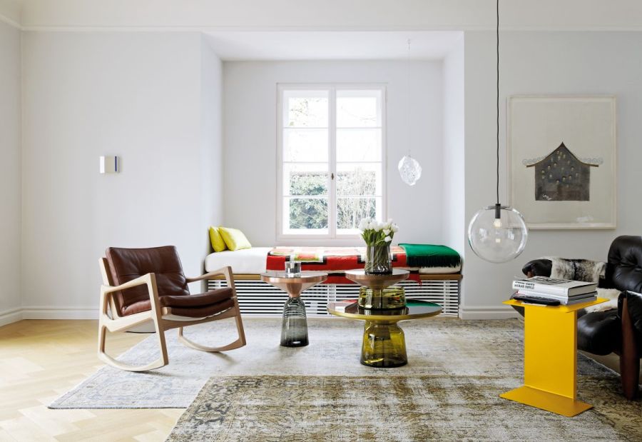 Wohnzimmer mit olivgrünem Bell Coffee Table Couchtisch, Sessel und Teppich für gemütliches Ambiente.