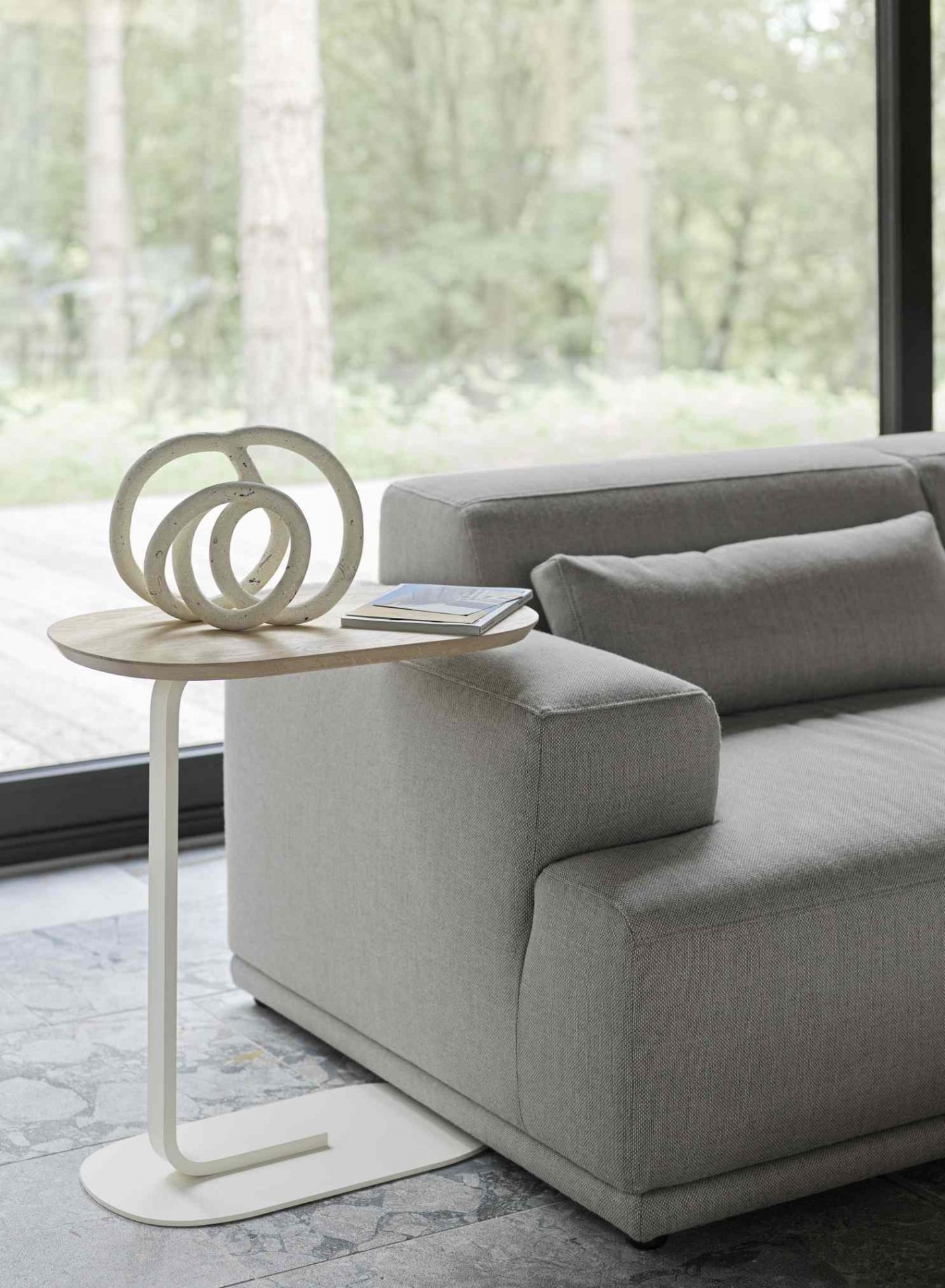 Helles Wohnzimmer mit grauem Connect Sofa und Beistelltisch mit Deko. Modernes modulares Sofa.
