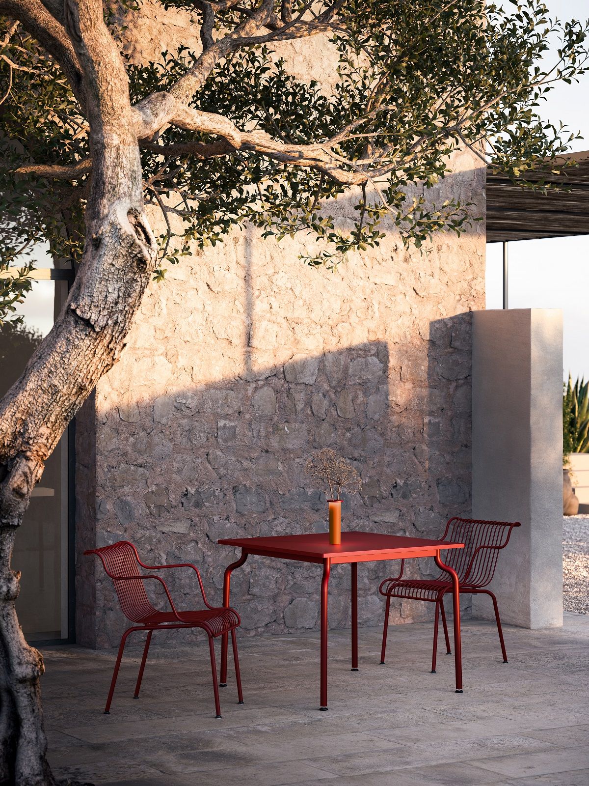 Roter South Outdoor Chair Stuhl von Magis mit Tisch auf einer Terrasse im Freien.