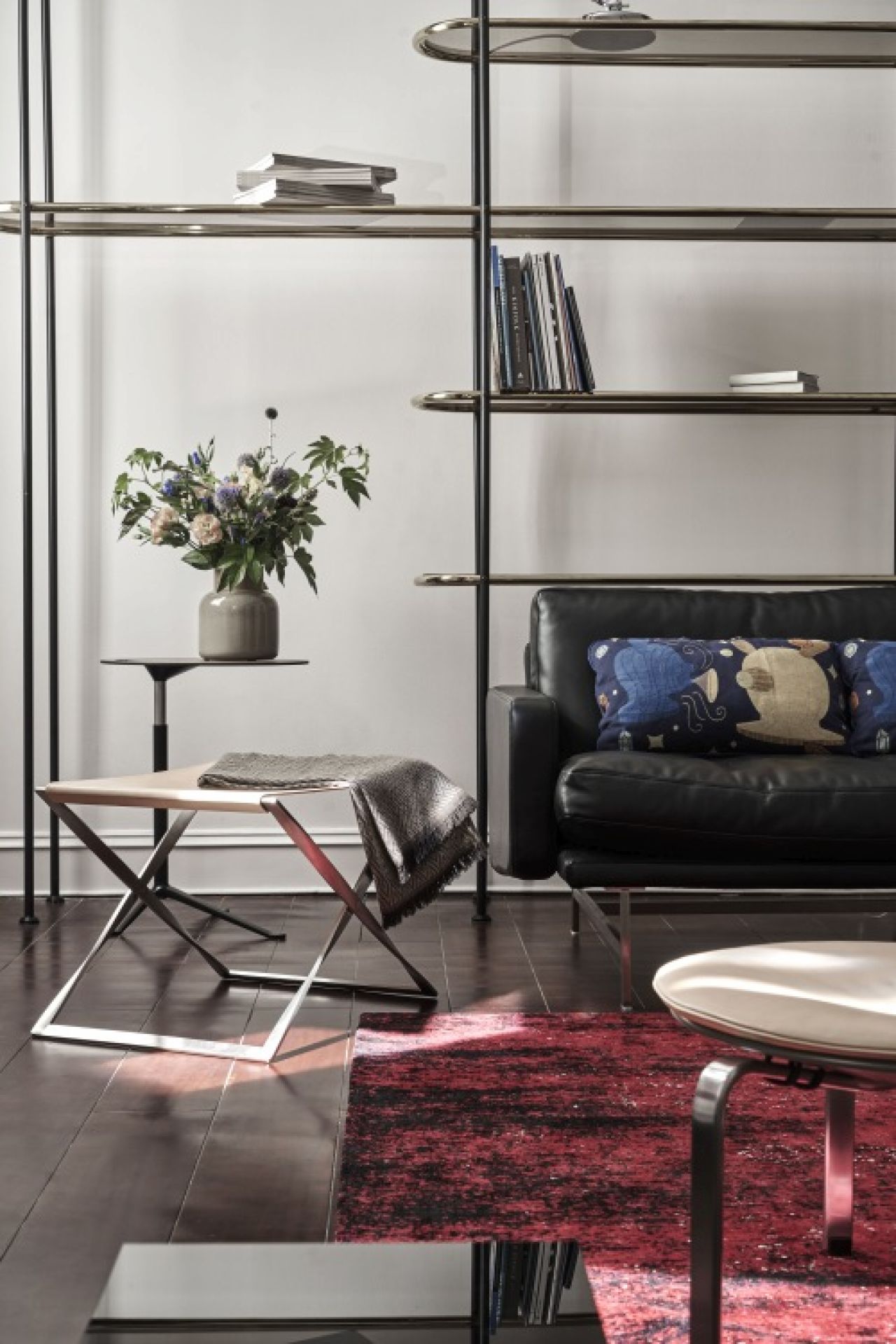 Eleganter PK91 Falthocker von Fritz Hansen mit Lederbezug und Decke im stilvollen Wohnzimmer.