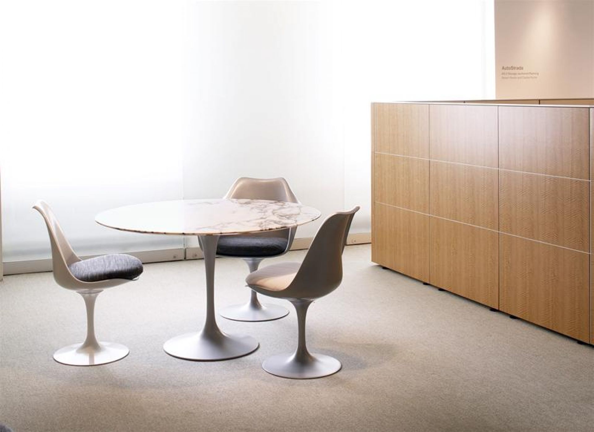 Helle Tulip Chairs von Knoll International mit grauem Sitzkissen und rundem Marmortisch.