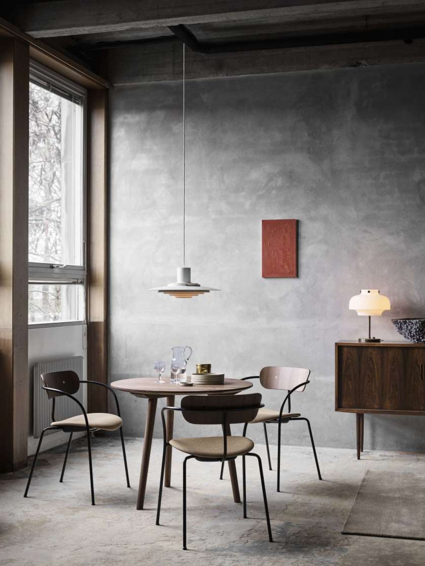 Pavilion AV4 Armchair Stuhl von AndTradition mit Armlehnen und Sitzpolster in einem Esszimmer.