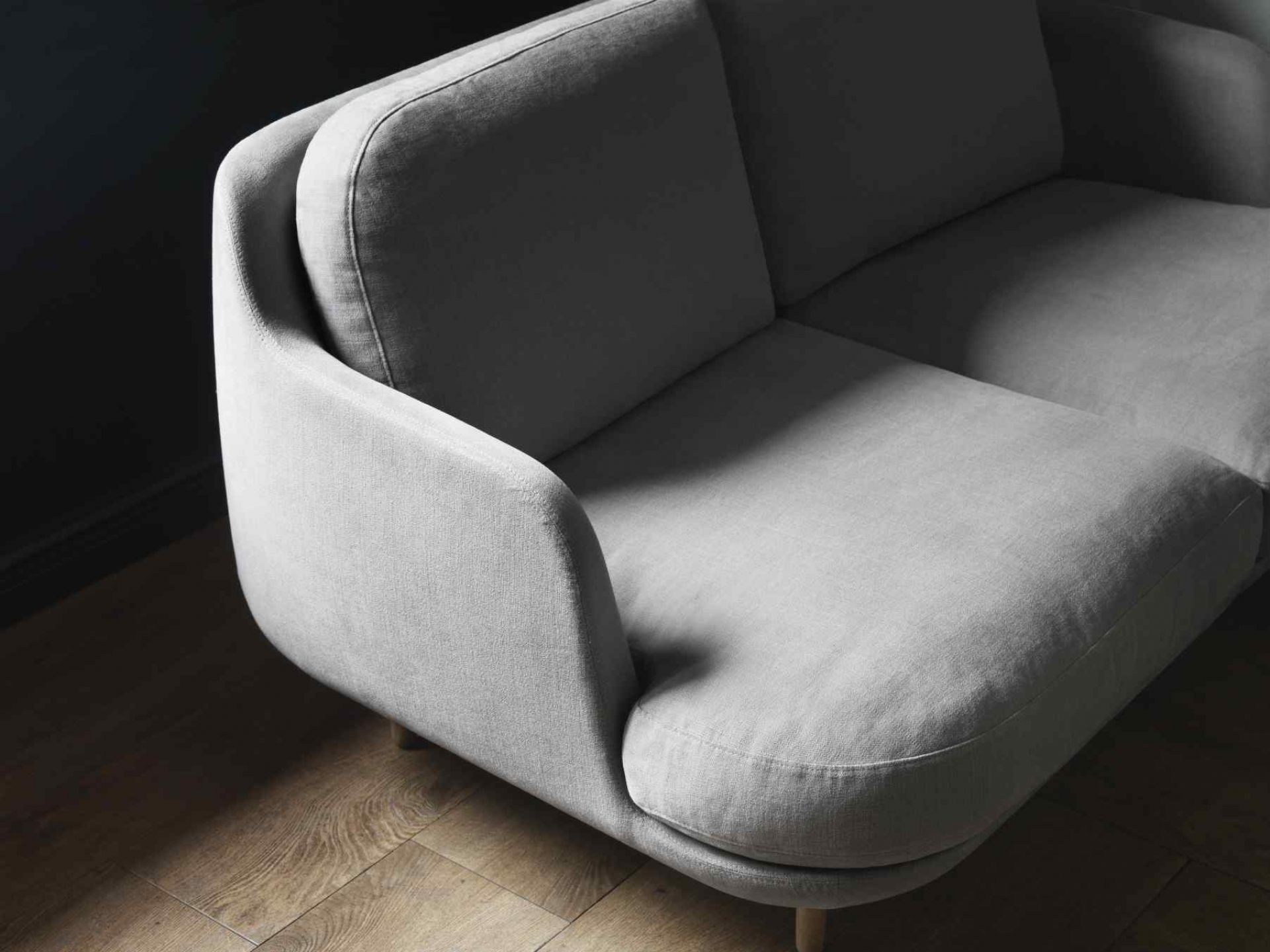 Nahaufnahme des grauen Fritz Hansen Lune Sofas, ein modernes 2-Sitzer Sofa mit Holzfüßen.
