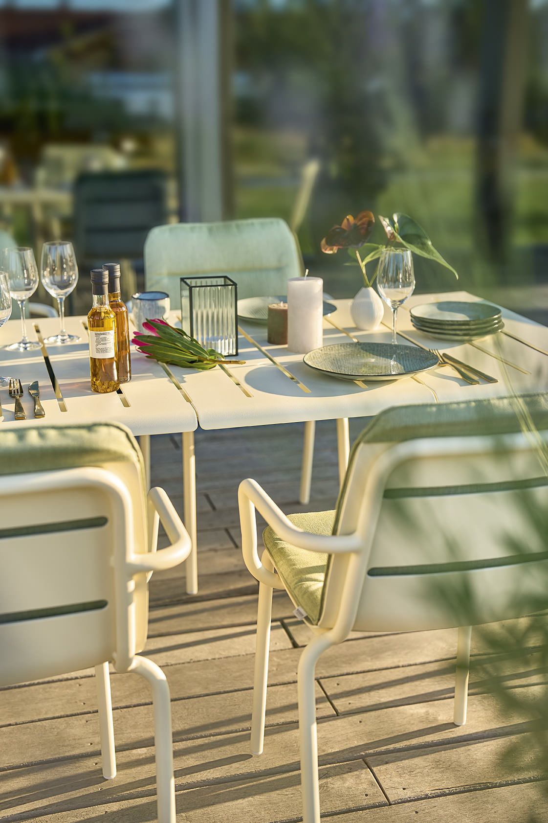 Weishäupl Vapio Tisch Outdoor mit stilvoller Tischdekoration, Geschirr, Gläsern und Stühlen auf einer Holzterrasse.