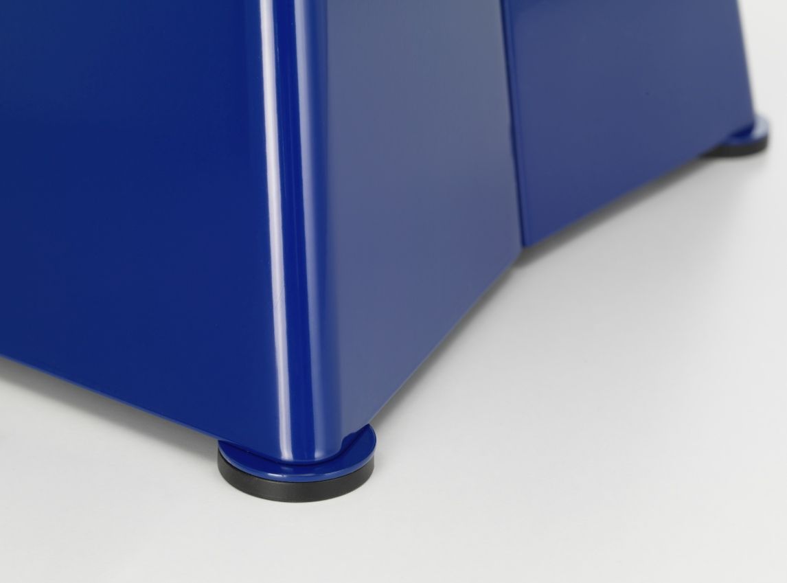 Detailaufnahme vom blauen Vitra Tabouret Métallique Hocker, der auf kleinen, runden Füßen steht.