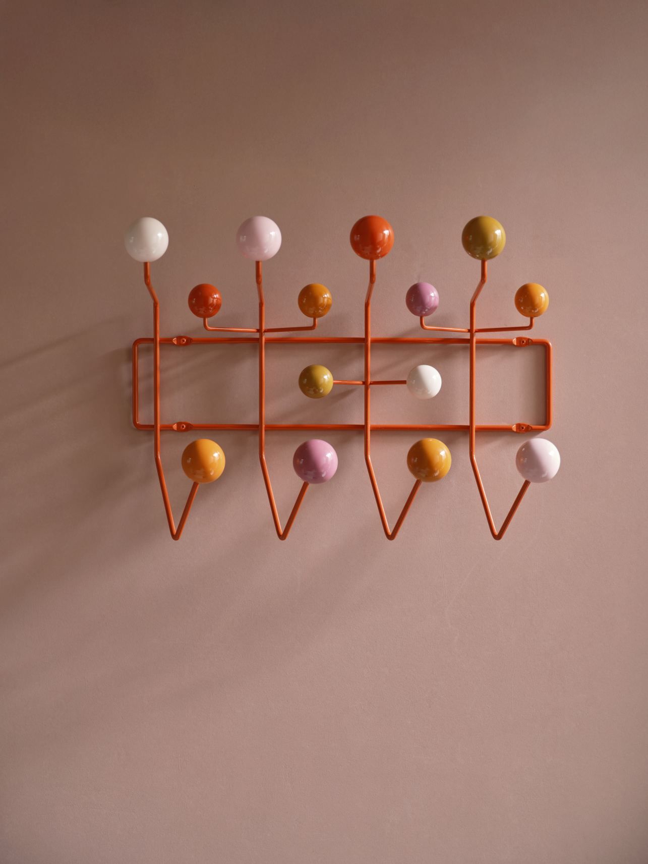 Eames Hang it all Garderobe Warm von Vitra mit bunten Kugeln an orangefarbenem Gestell.