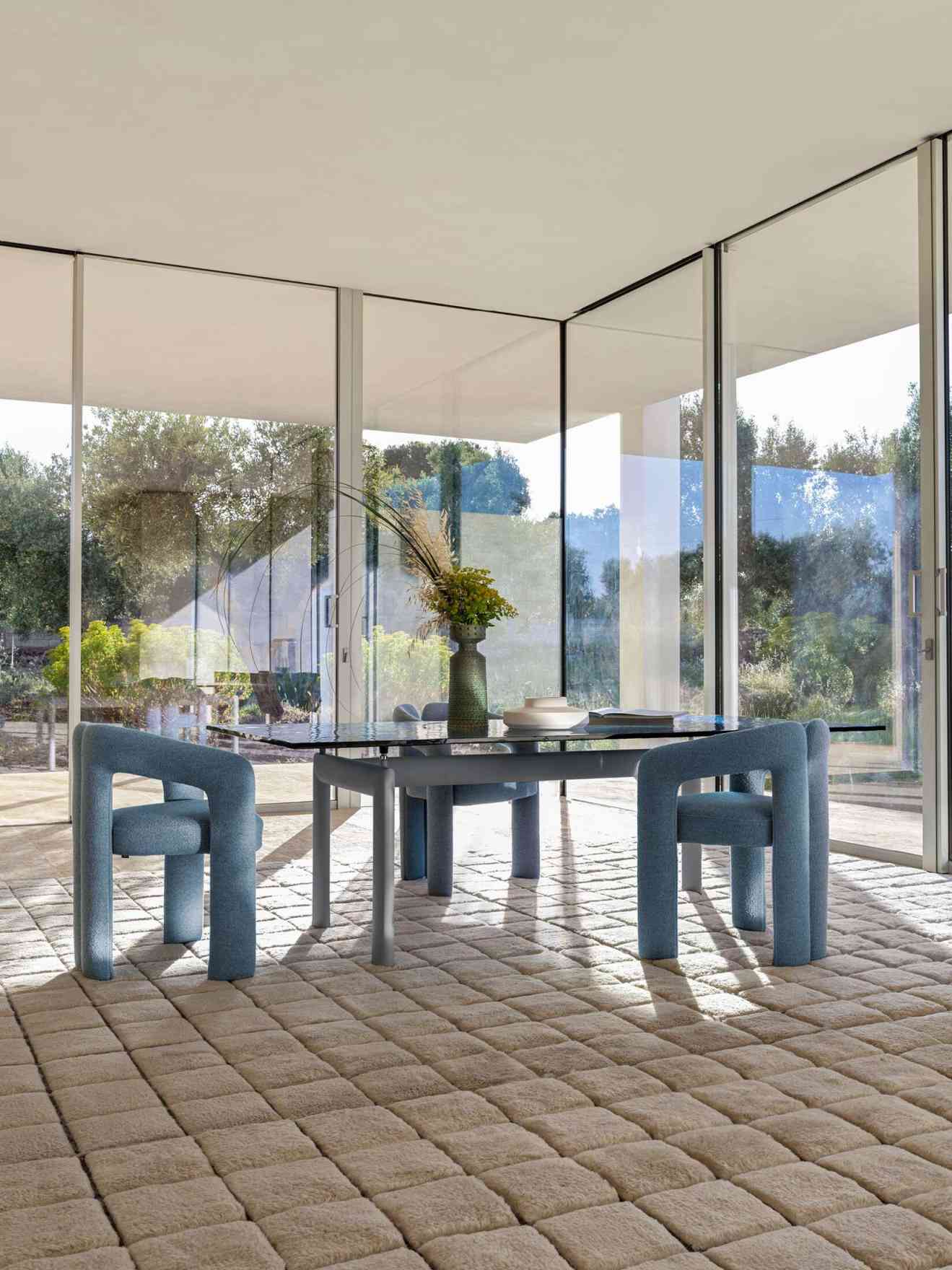 Blauer 562 Dudet Sessel von Cassina am Esstisch in modernem Interieur mit großem Fenster.