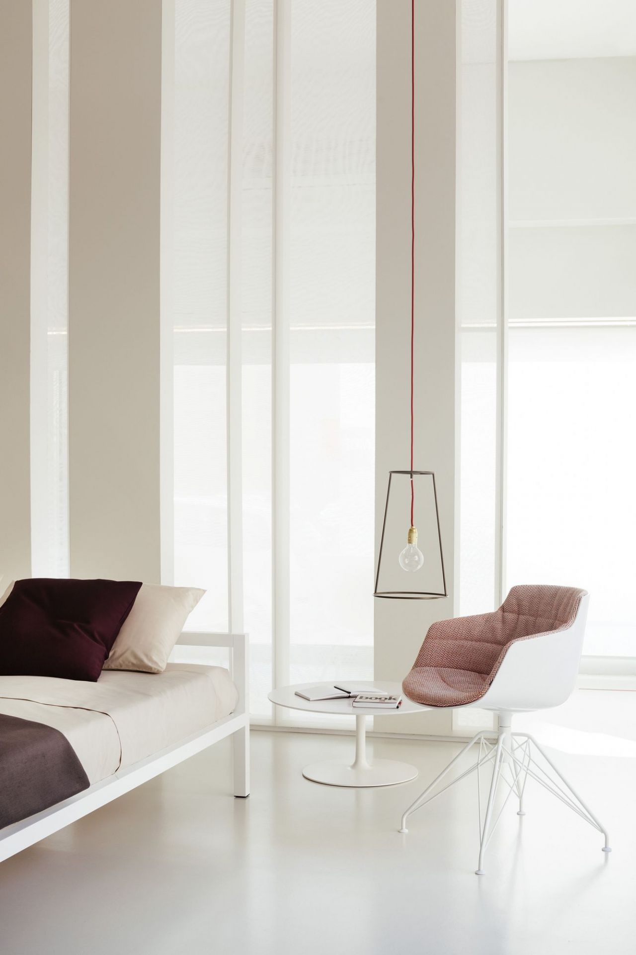 Minimalistisches Wohnzimmer mit MDF Italia Flow Low Table Couchtisch, Sessel und Bett in Weiß.
