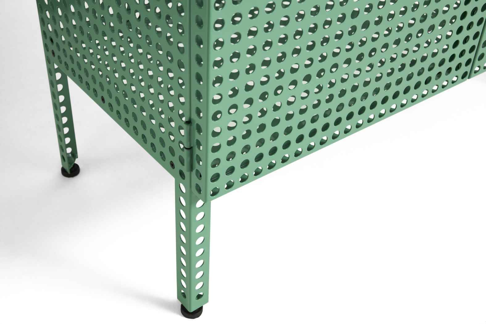 Detailaufnahme des grünen Hay Perforated Cabinet Sideboards mit Lochmuster und schwarzen Füßen auf weißem Hintergrund.