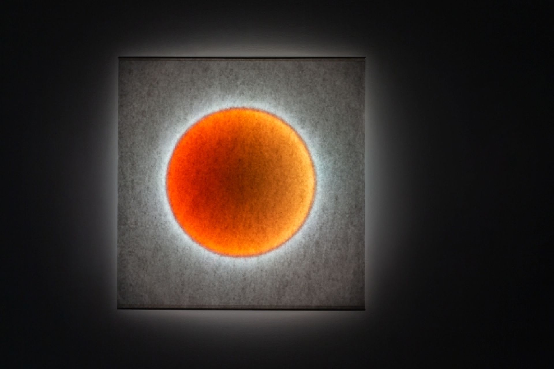 Moodmoon Wandleuchte: Quadratische Designerlampe mit orangem Lichtkreis für stimmungsvolle Beleuchtung im Wohnraum.