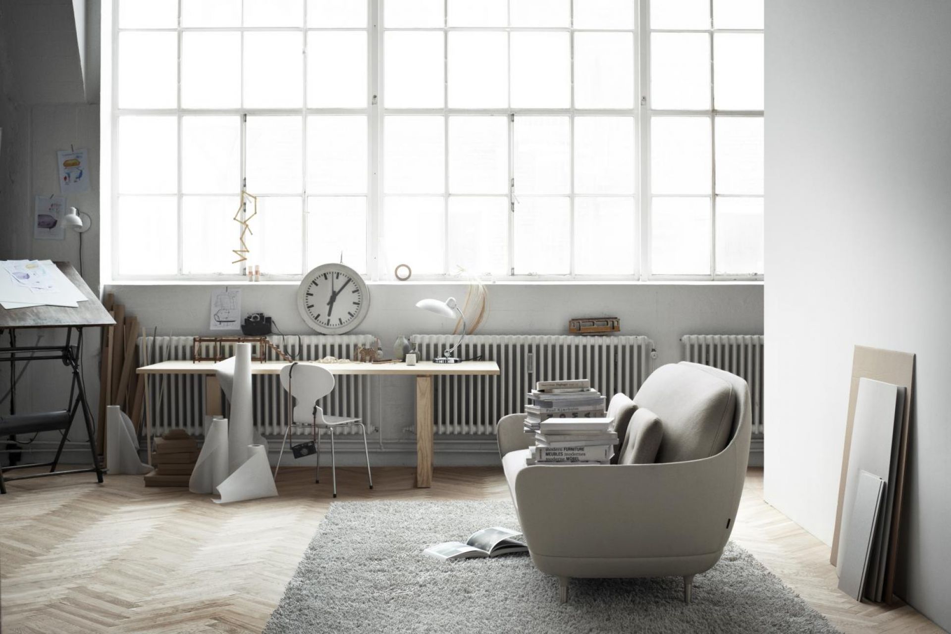 Heller Raum mit Favn Sofa von Fritz Hansen, grauem Teppich und großem Fenster für viel Tageslicht.
