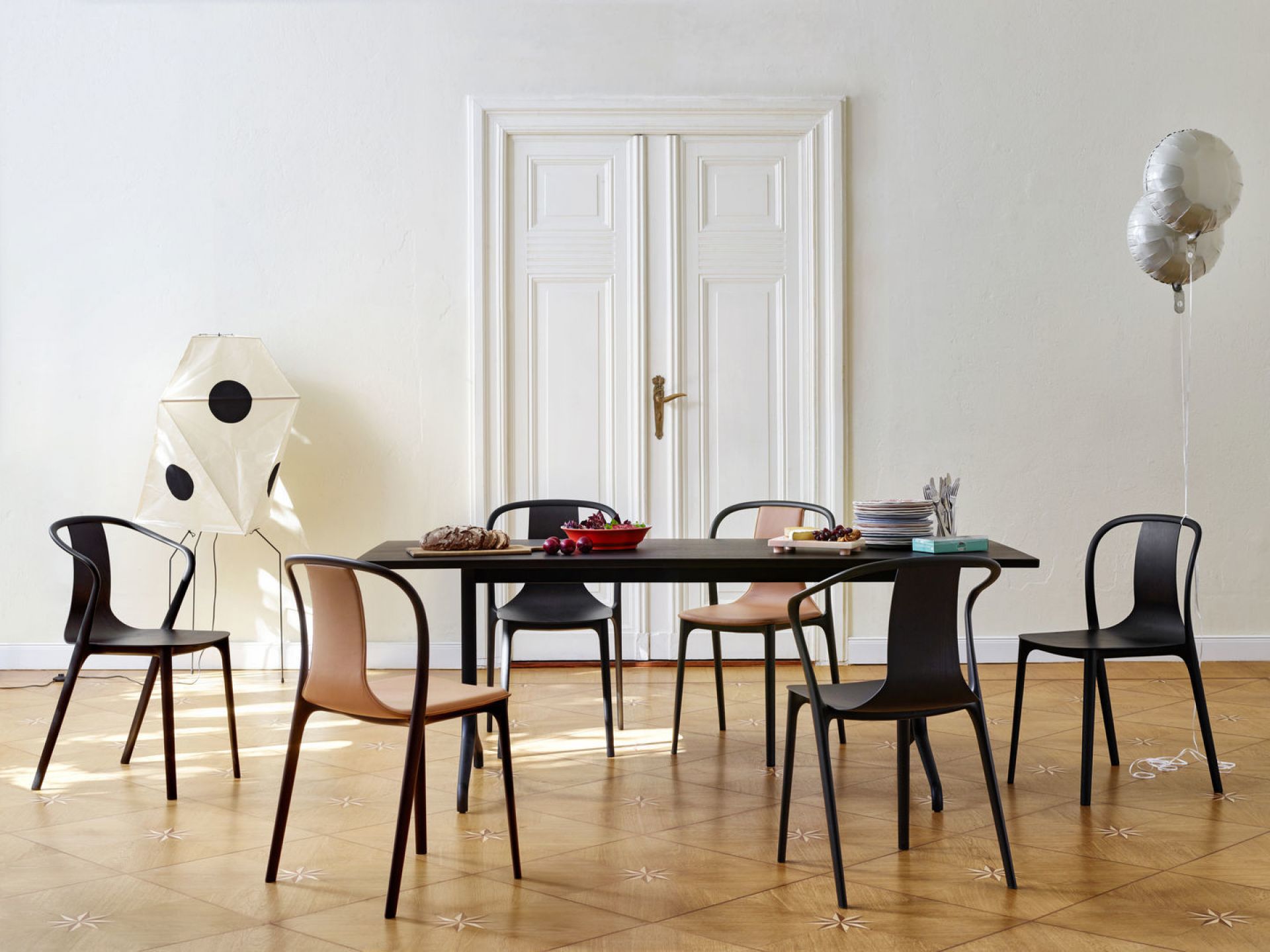 Esstisch mit mehreren Belleville Stühlen in Eiche Natur und schwarzem Gestell. Designstuhl von Vitra.