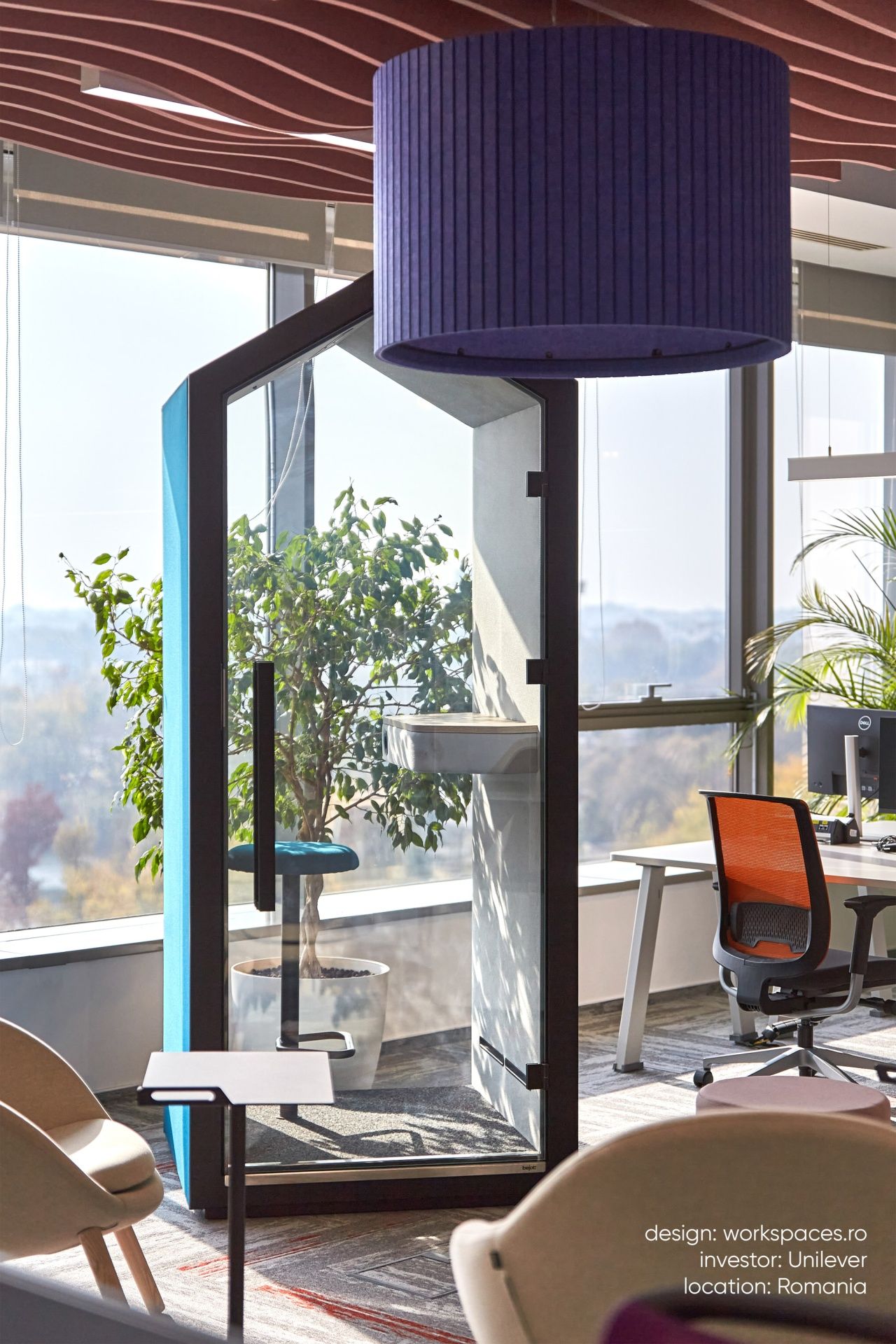 Bejot treehouse THS Akustikkabine im modernen Büro mit Glasfront, Steh-Sitzgelegenheit und Pflanzen für ruhiges Arbeiten.