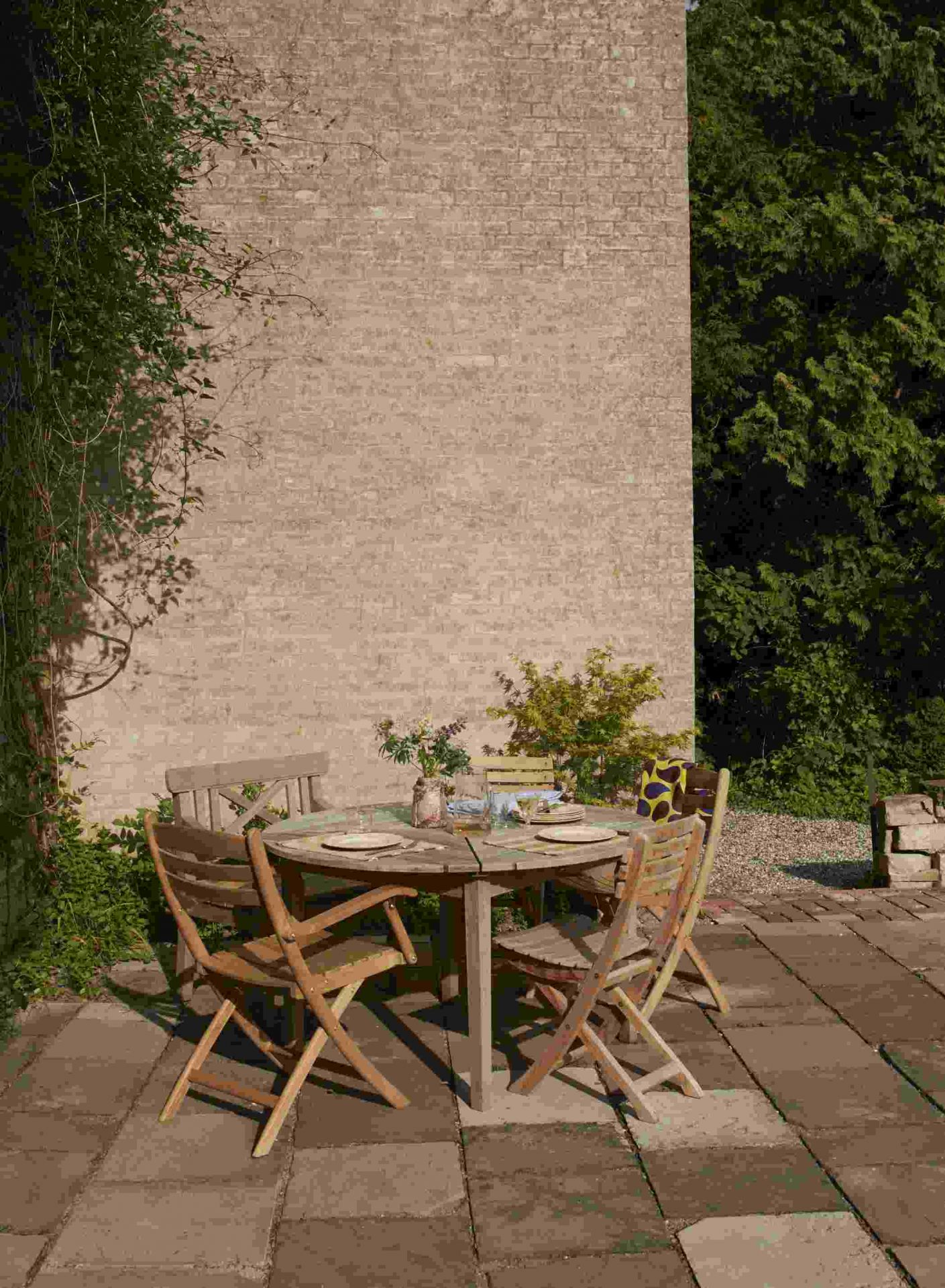 Drachmann Tisch von Skagerak by Fritz Hansen mit Holzstühlen auf einer Terrasse im Garten.