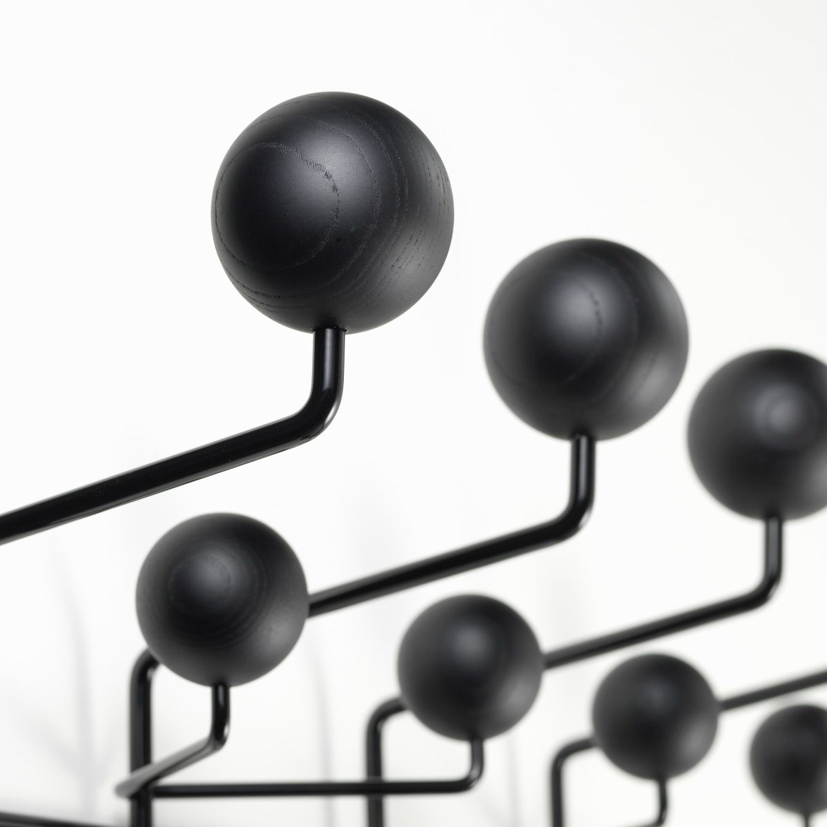 Detailaufnahme der Eames Hang it all Garderobe von Vitra in Esche schwarz, moderne Wandgarderobe.