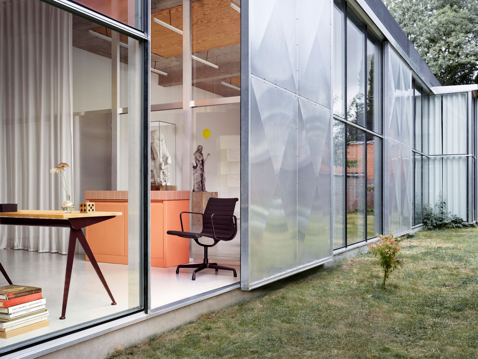 Vitra Compas Direction Schreibtisch im modernen Büro mit Designmöbeln und Blick in den Garten.