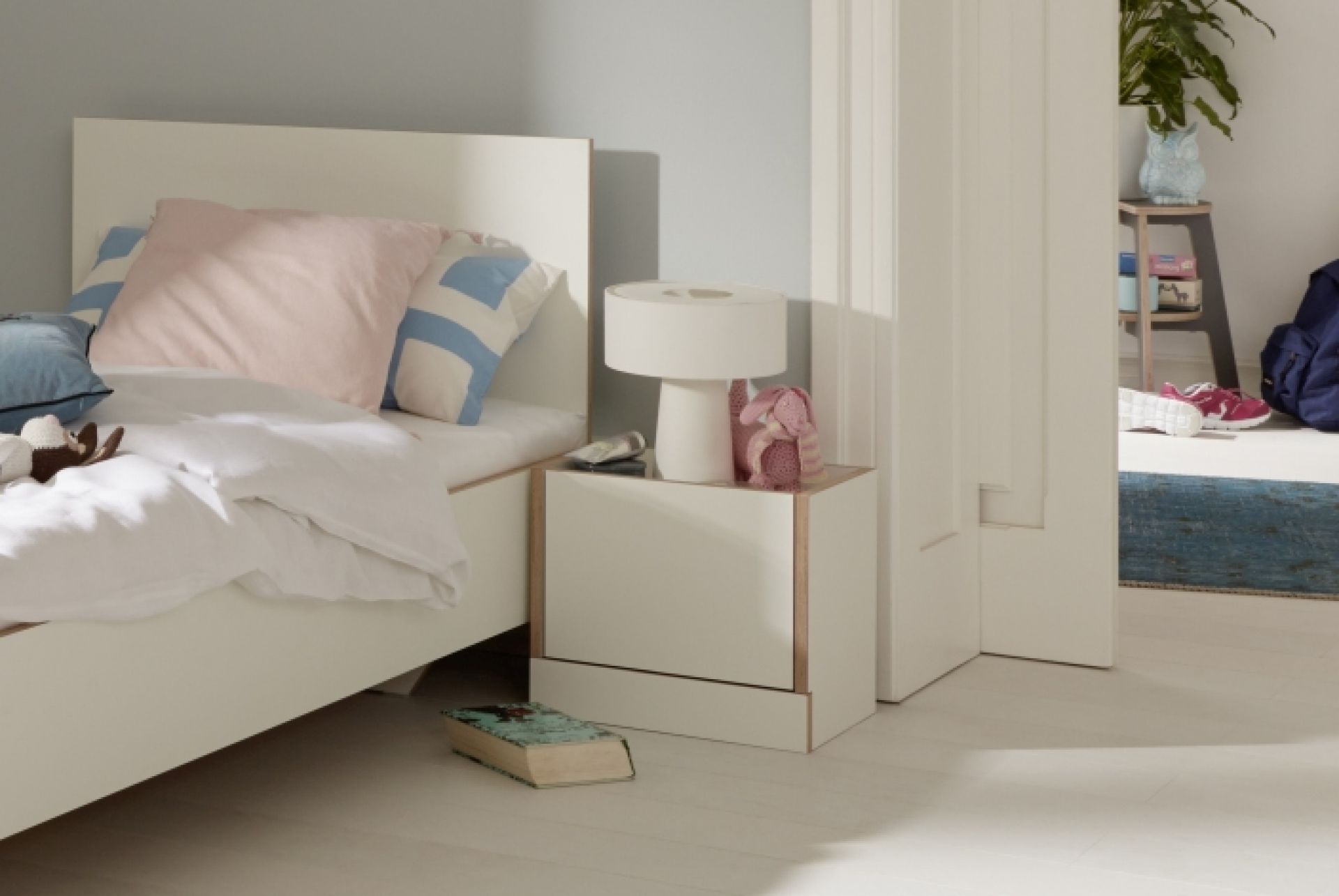Weißes Flai Bett von Müller Möbelwerkstätten (140 cm) mit Nachttisch im Schlafzimmer. Modernes Design.