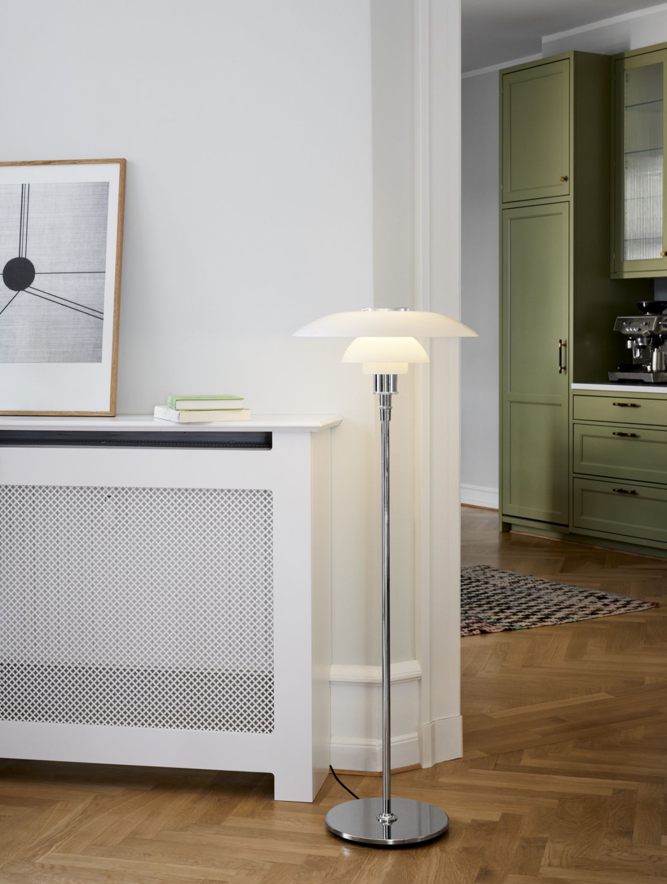 Moderne Stehlampe mit mehrschichtigem Schirmdesign und Chromfuß im stilvollen Wohnzimmerambiente.