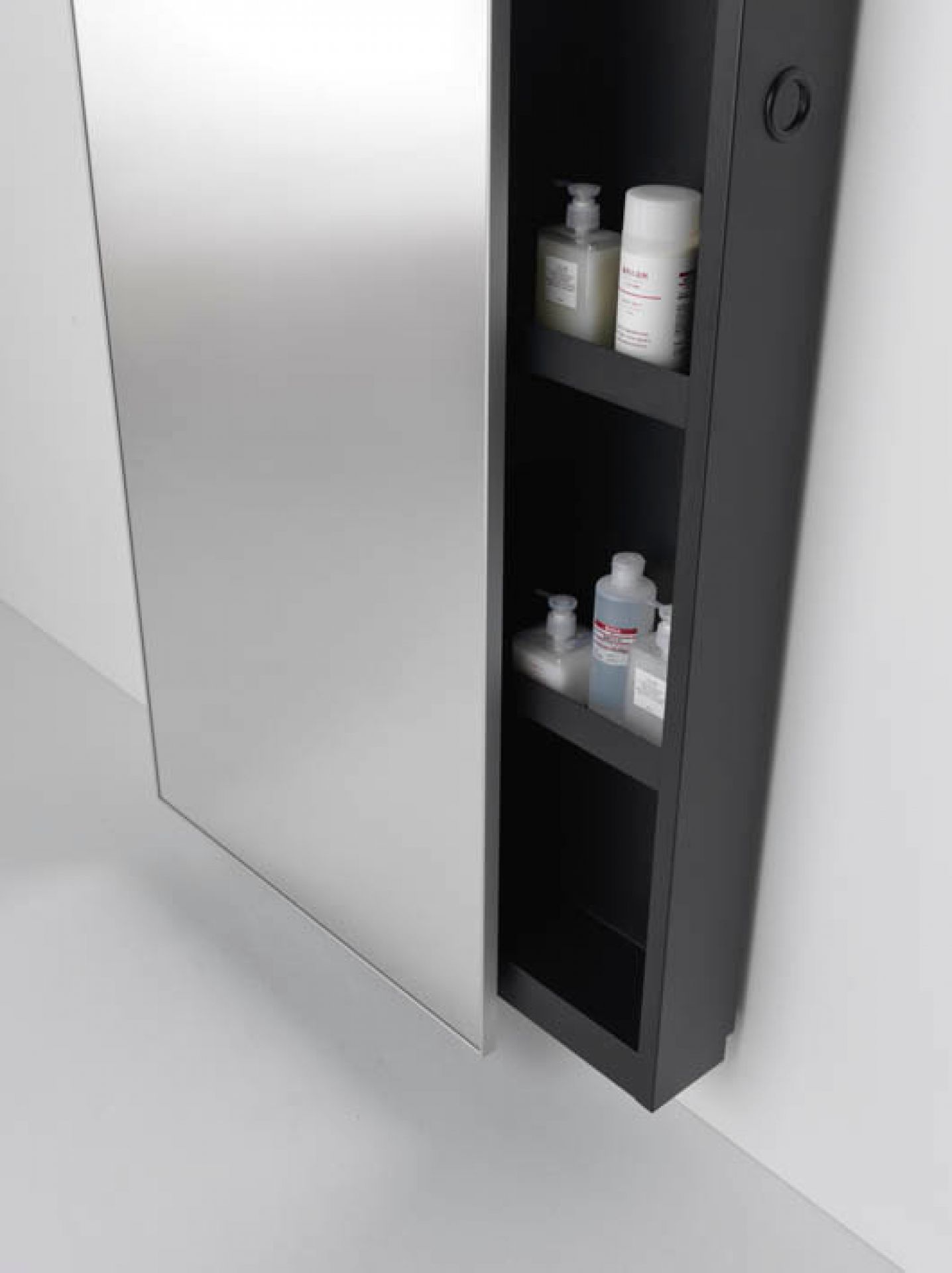 Detailaufnahme: Backstage Spiegelschrank von Casamania Horm mit schwarzem Regal und Badezimmerartikeln. Moderner Spiegelschrank für Badezimmer.